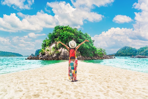 female backpacker enjoying summer on a scenic tropical beach